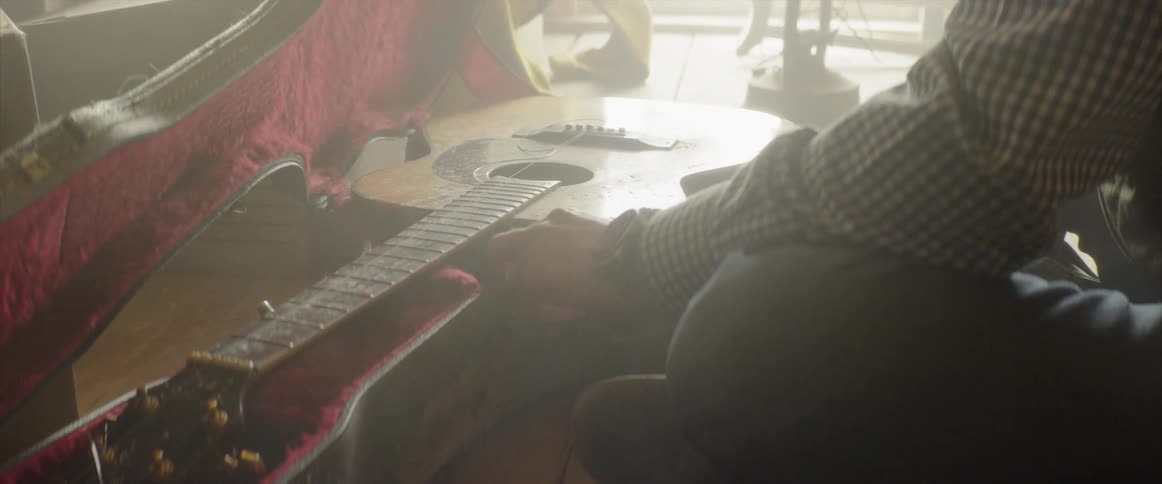 Man removes a guitar from its case