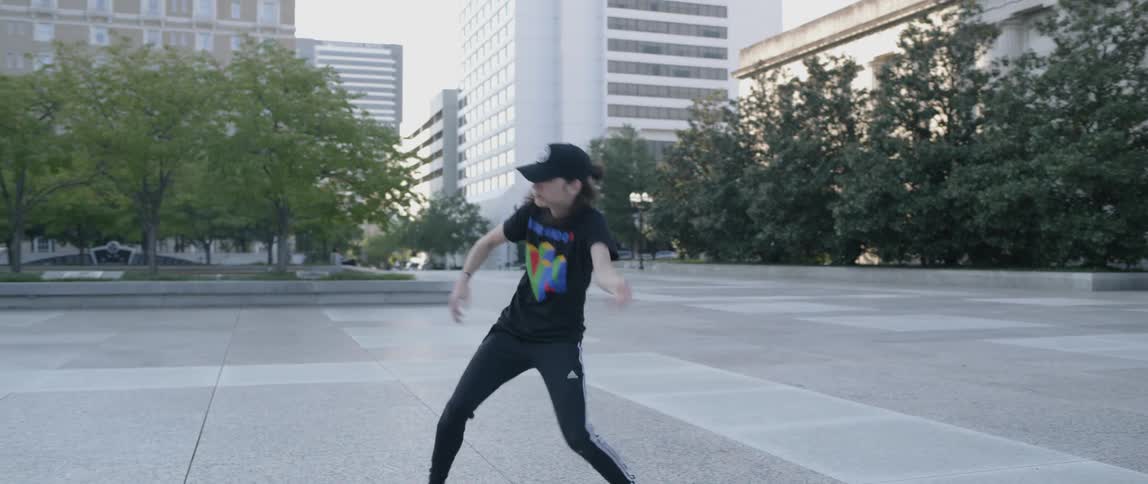 A dancer performs on a city sidewalk