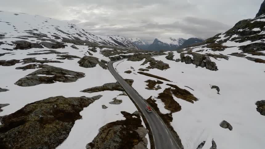 A vehicle drives down a winding mountain road