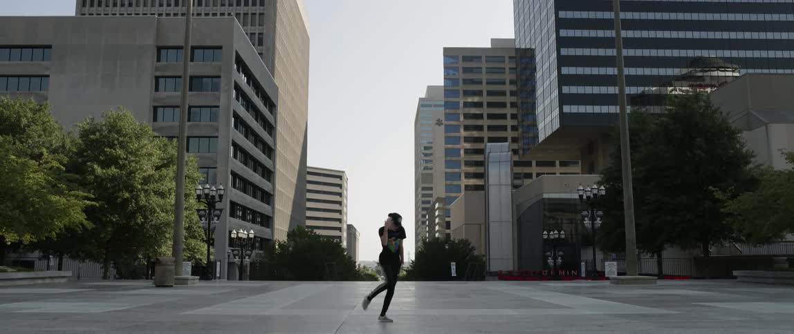 A person is dancing in the intersection of the city