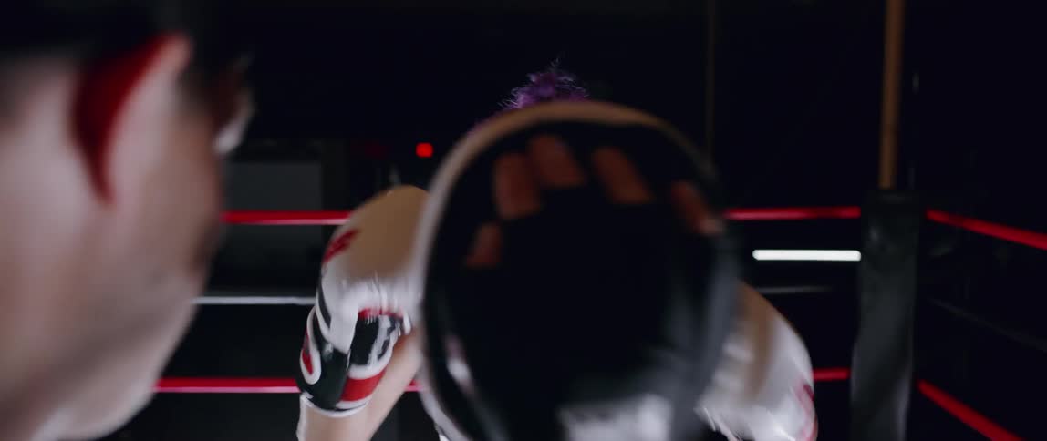 Woman practices boxing with trainer