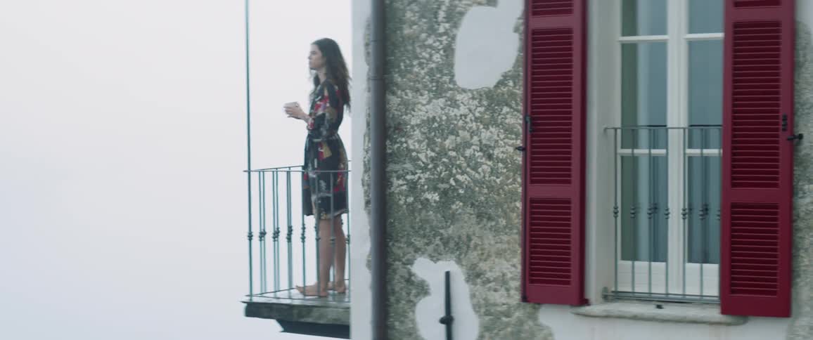 Woman standing on balcony in rural town