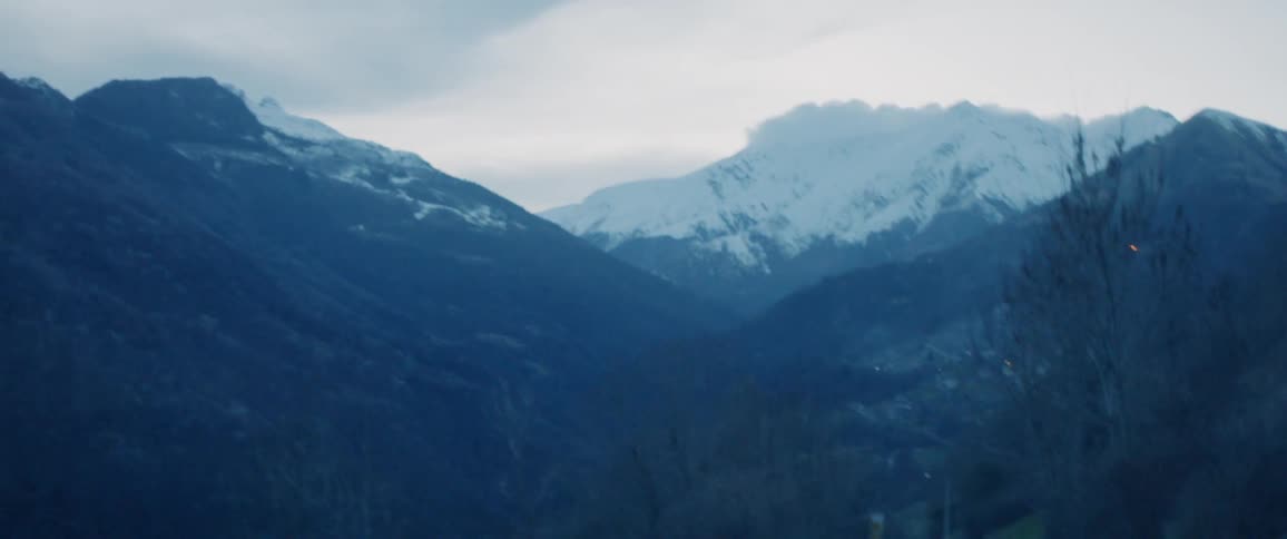 Path winds through the mountains on a cloudy day