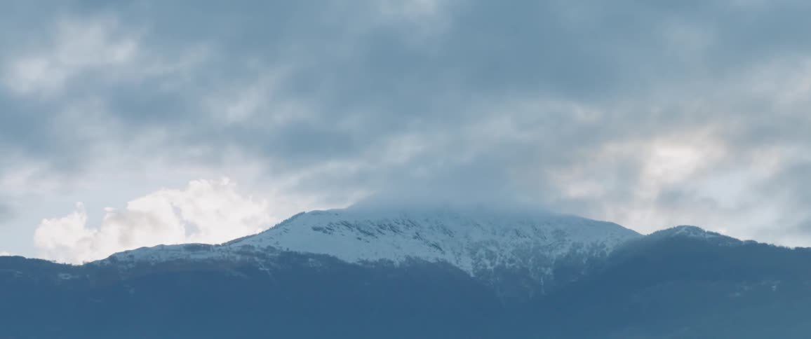 Snowy, cloud- covered mountain