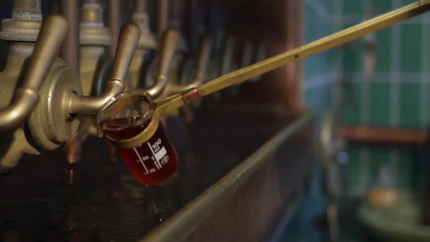 A handled glass test pours liquid in a reservoir