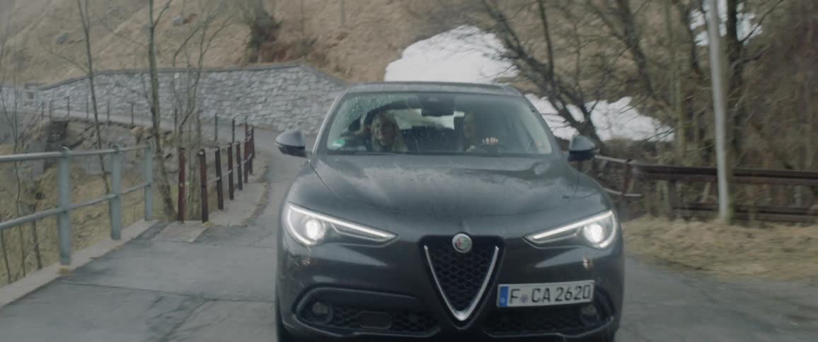 Couple driving up a rural mountain road in a car