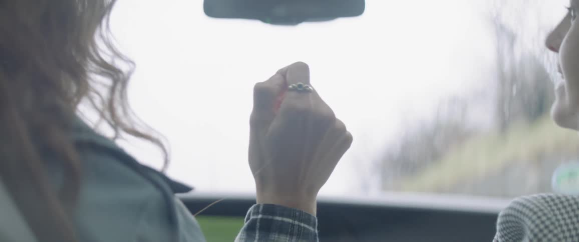 A person holds their hand up as they drive