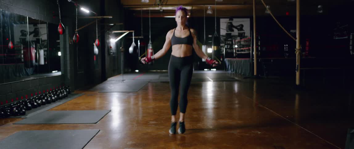 Woman jumps rope hopping swiftly in a gym