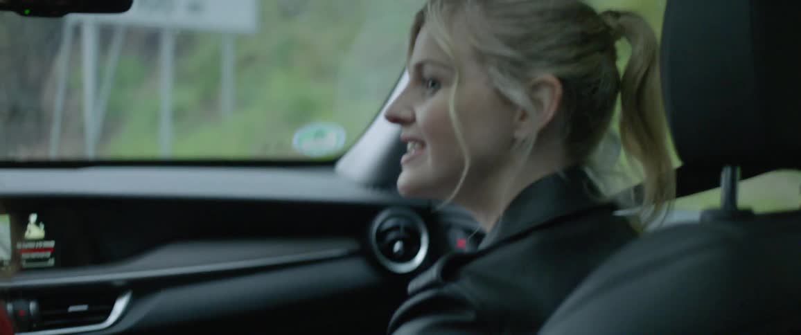 A woman rides in the passenger seat of the car