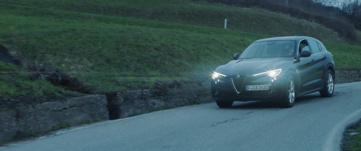 Car drives down a country road in the evening