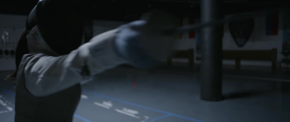 A fencer practices in the gym