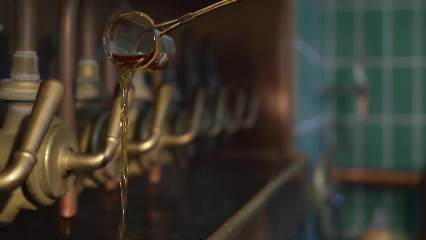 Liquid is poured from a long handled glass