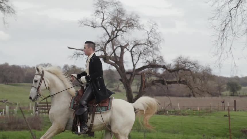 The man rides a white horse