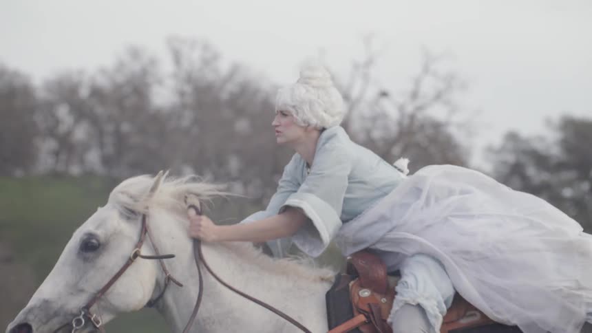 Woman in period costume rides horse