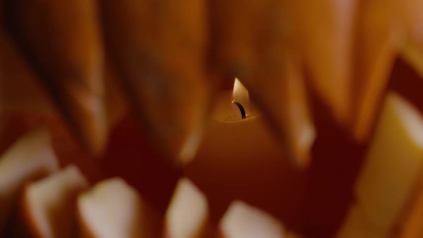 Candle burning behind a jagged opening