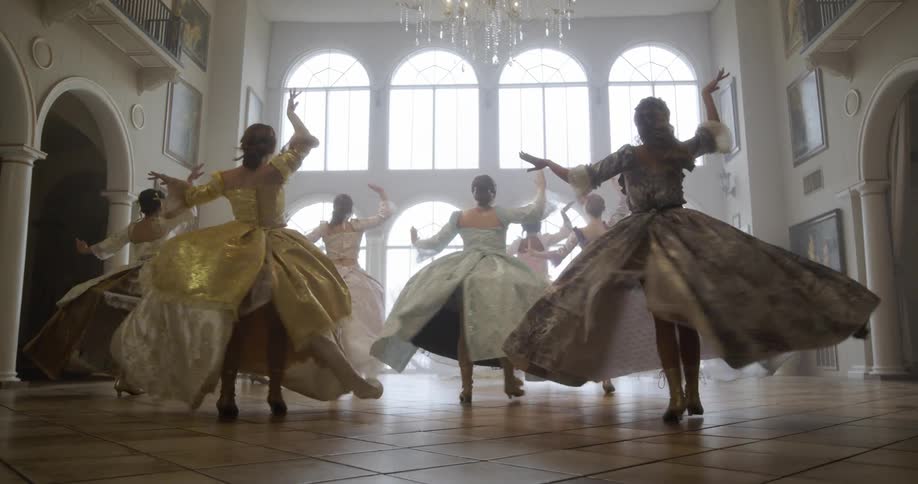 Women in old fashioned dresses dance in unison