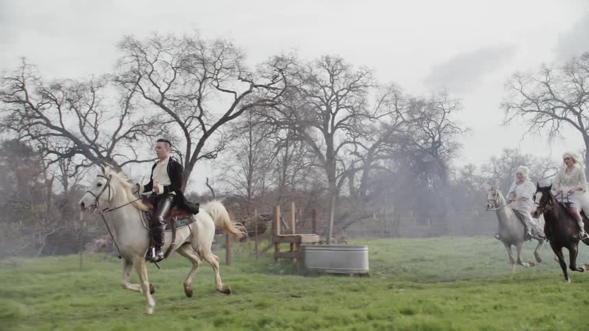 People ride horses through the field