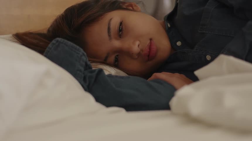 A woman lays on a bed