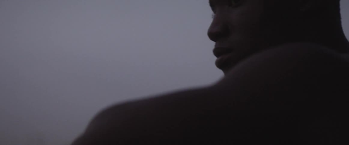A man sitting outside looks around