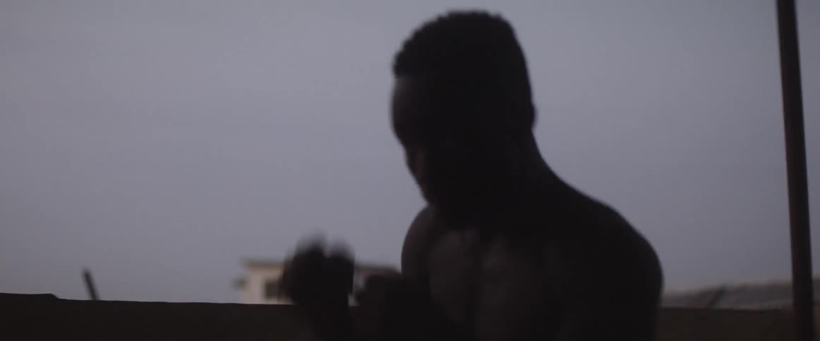 Man practices punching on a balcony in a remote village at sunset