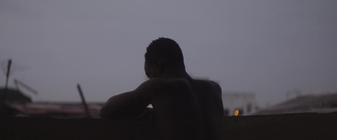 Man stands on rooftop looking down