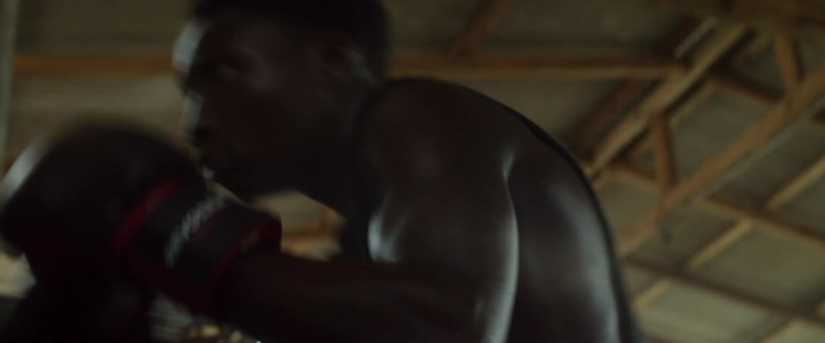 The man is shadow boxing with large gloves