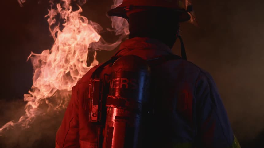 Firefighter with gear near fire