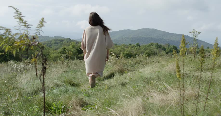 A woman walks in a rural field