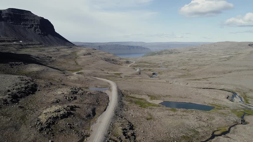 The canyon has small pools of water in the distance