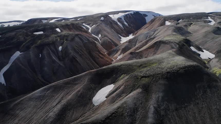 Snow sparsely covers the hilly landscape