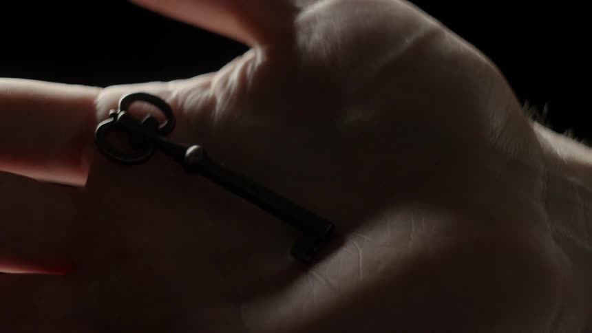 A hand drops an old key