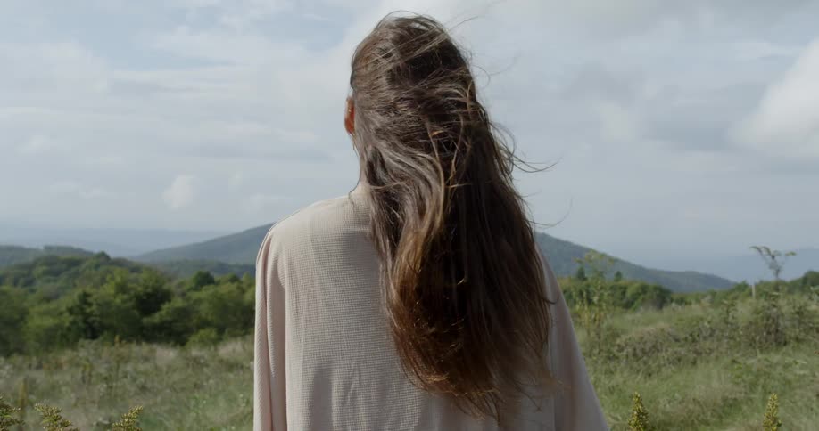 A woman stands outside in the breeze