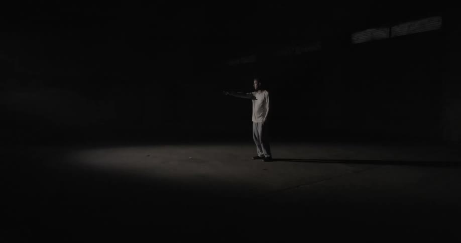 A man points in a room with a strobing light