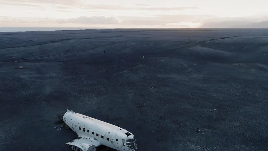 A plane wreckage sits in the middle of the open plains