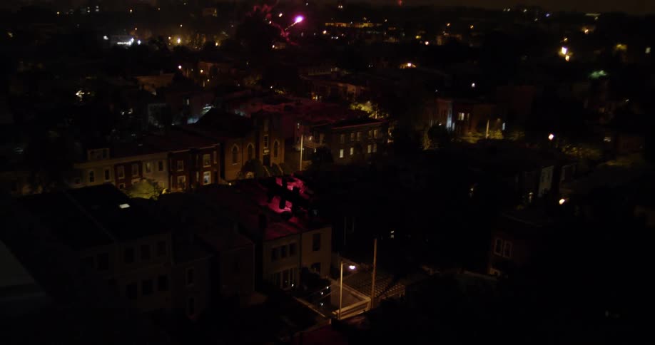 Fireworks explode in the dark sky over the city