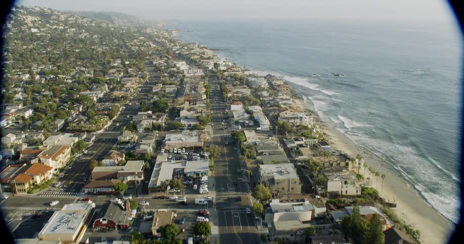 Ocean waves splash to shore next to a city