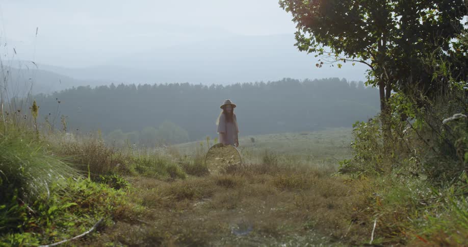 The woman is in the grass ahead
