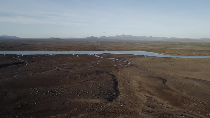 A river streams between the flat plains