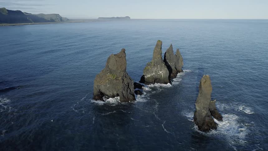 Waves flow towards the cliff lined shore