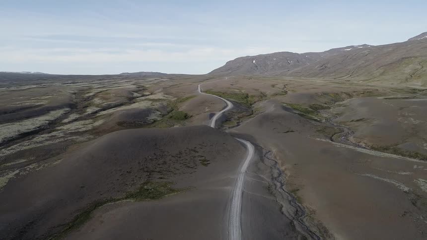 A road winds through a desert landscape