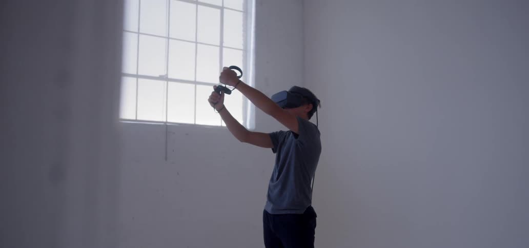 Man wearing virtual reality gear moves his arms around