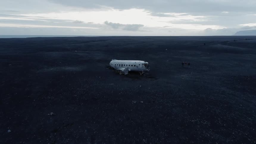Aerial view of a man standing near a crashed plane