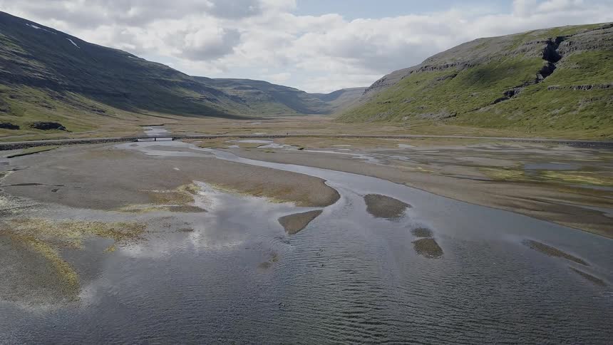 Clouds hang above the flowing lake waters