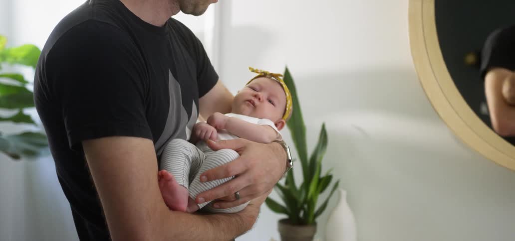 A man cradles a baby in his arms