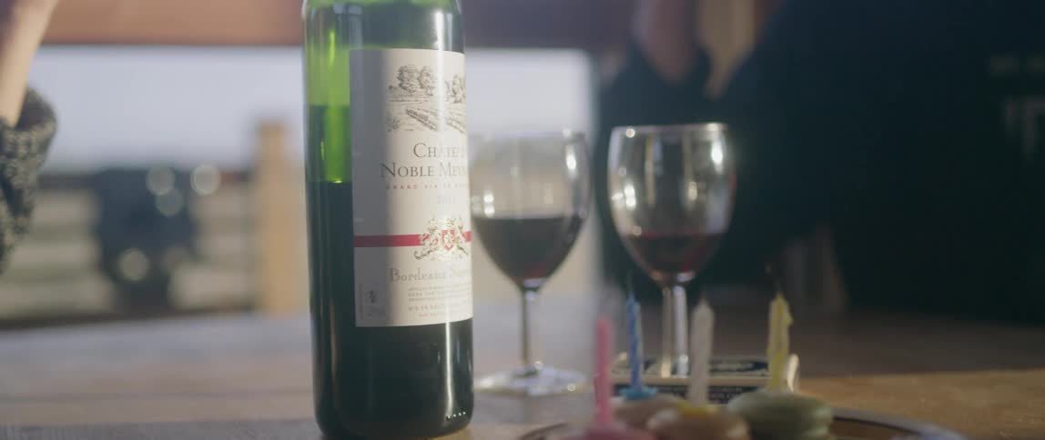 Man and woman sit at a table eating and drinking wine