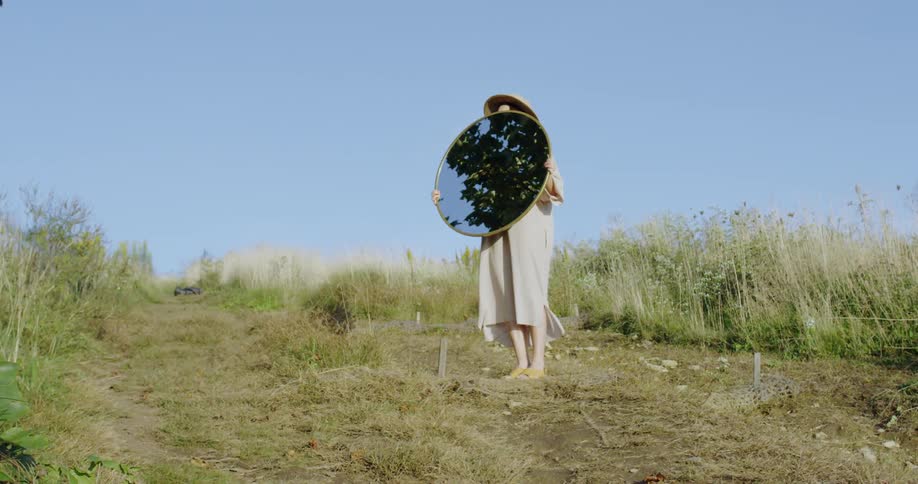 A woman holds a mirror