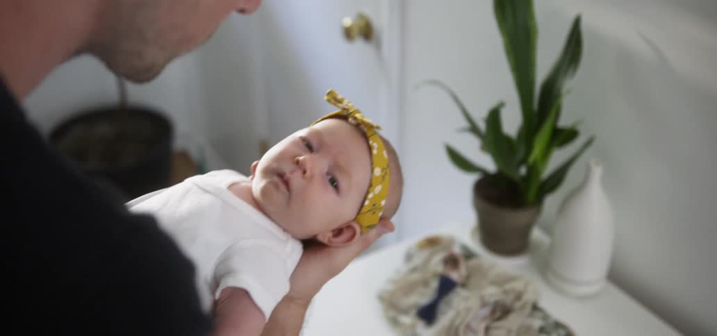 Infant held by man gazes at camera