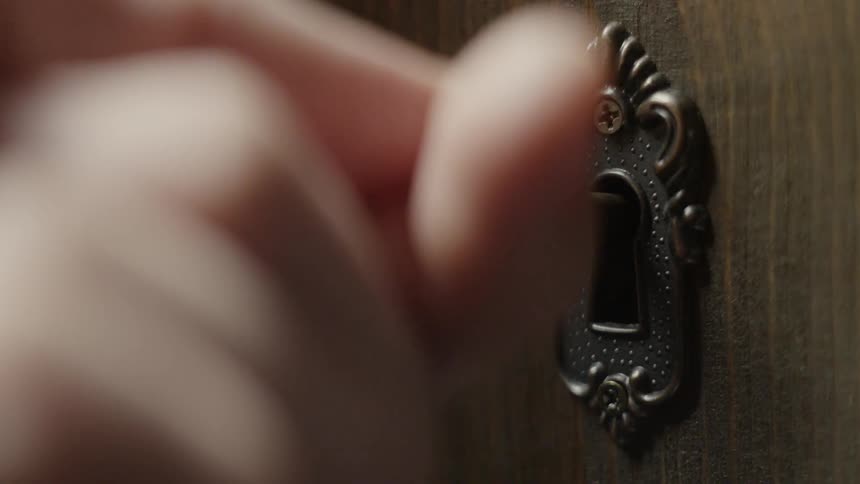 A person puts the key into the door