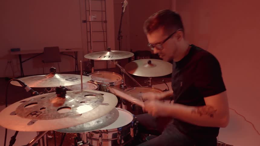 A man quickly plays the drums