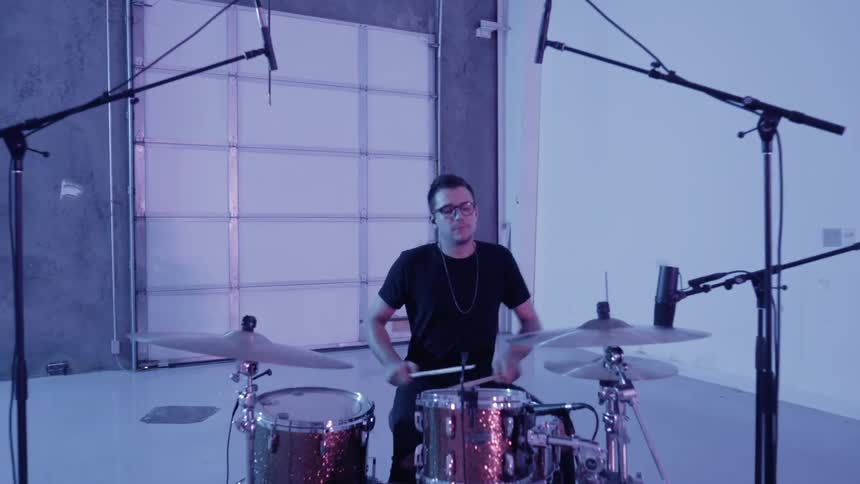 A man plays drums in an empty room